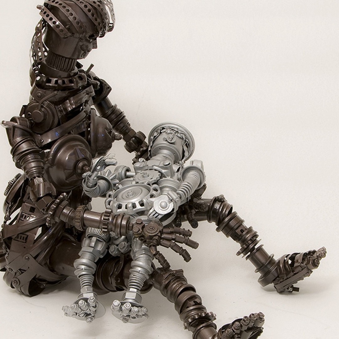 Adoção, figura de metal acolhendo uma pequena figura em prata